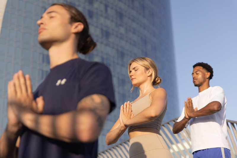 3 personas meditando en el aire libre