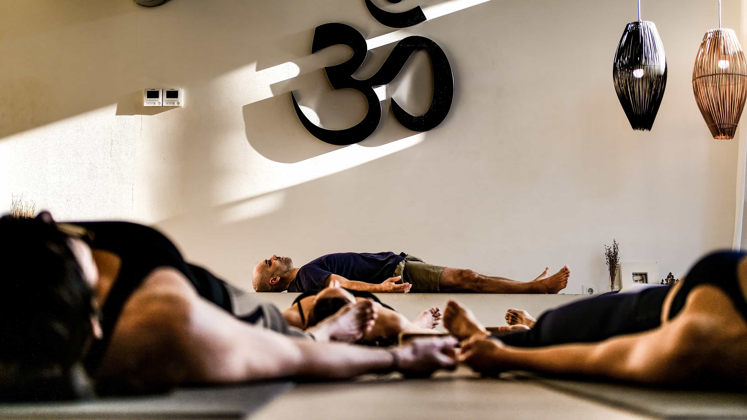 Clase de yoga en postura de descanso para favorecer el bienestar integral.