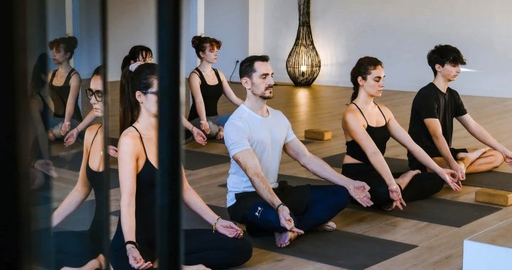 Personas practicando yoga y meditación durante un momento de desconexión digital.