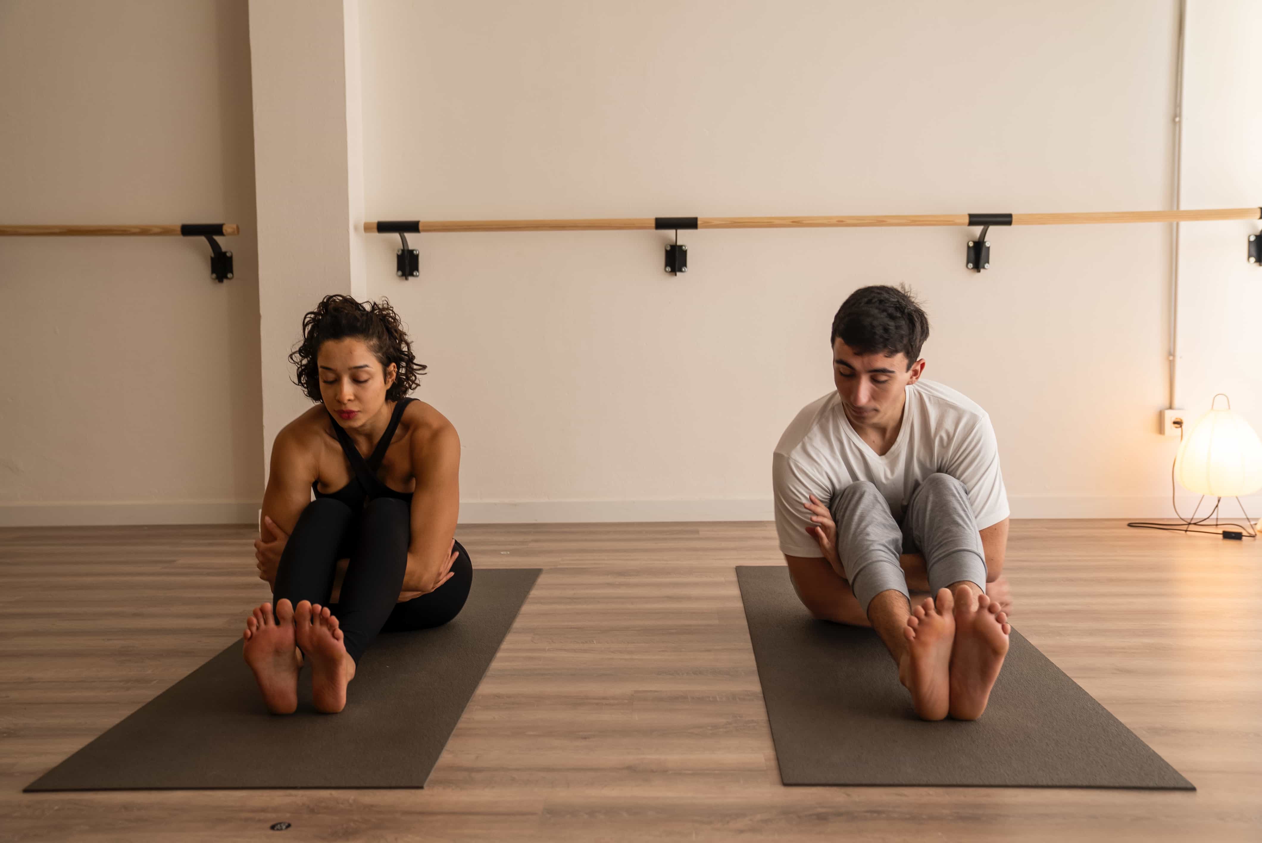 Dos personas practicando yoga de forma suave después de un periodo de inactividad